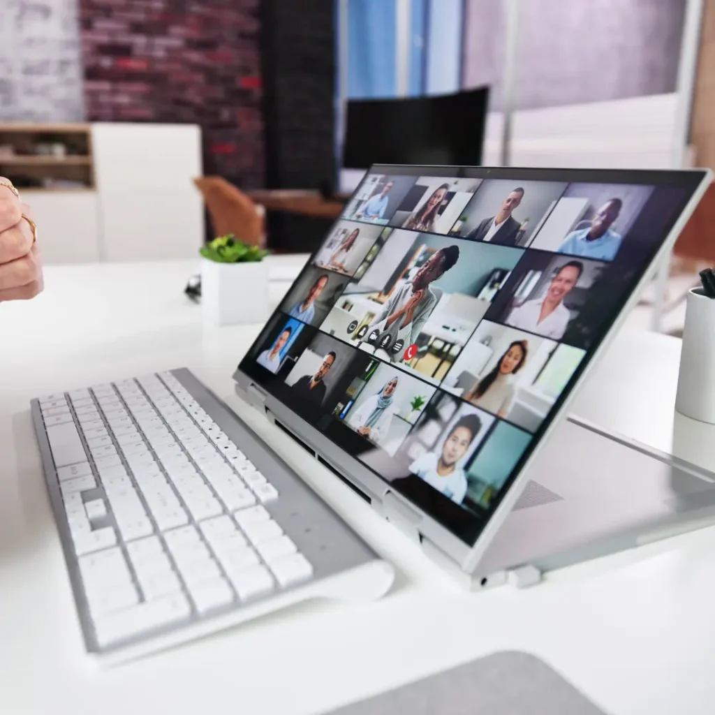 Laptop showing diverse professionals in a virtual meeting — representing AssistIQ’s remote support team.